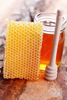 عکس با کیفیت موم عسل و شیشه عسل روی میز MJ002306