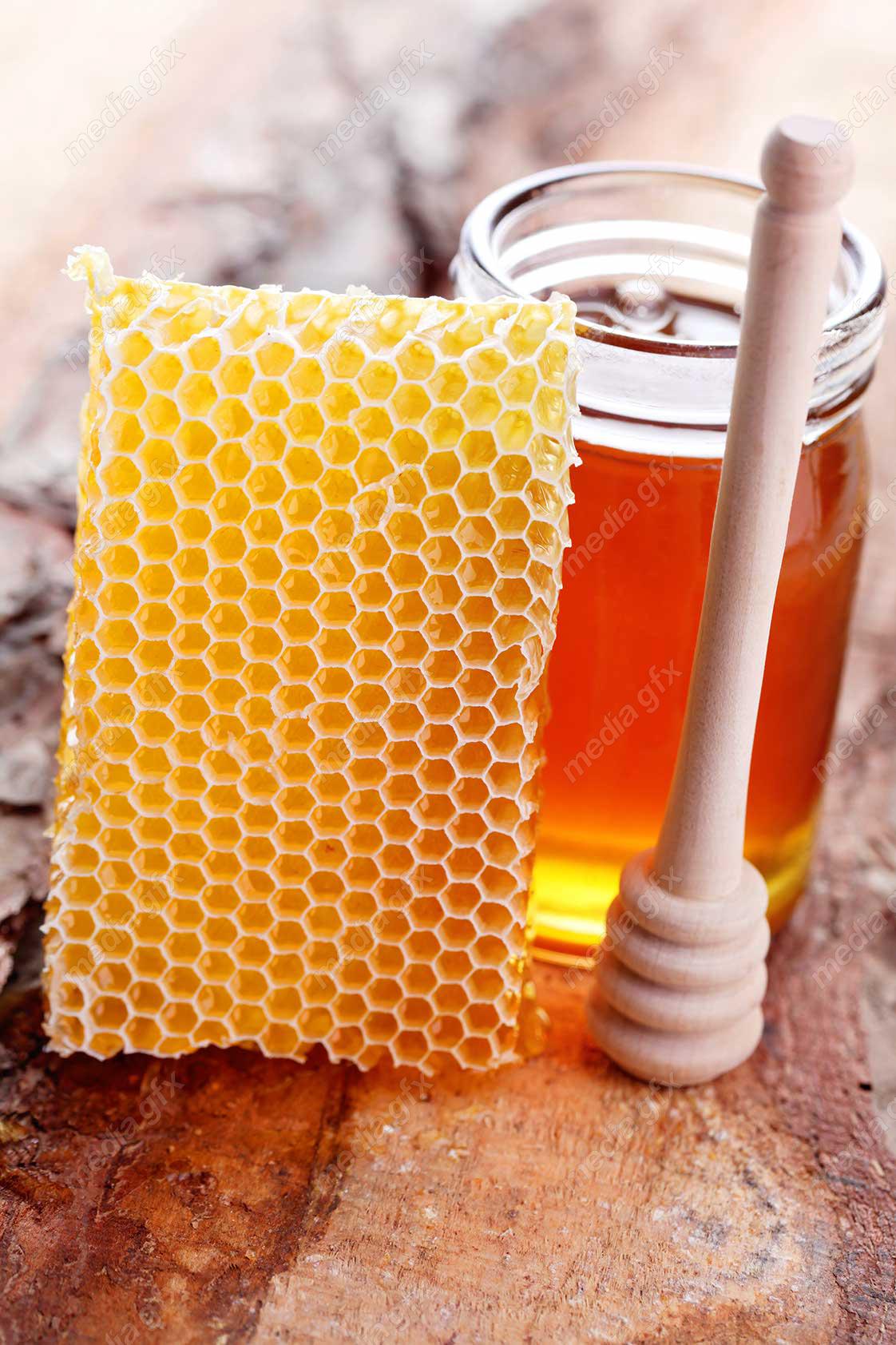 عکس با کیفیت موم عسل و شیشه عسل روی میز MJ002306