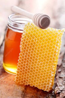 عکس با کیفیت موم عسل و شیشه عسل روی میز MJ002312