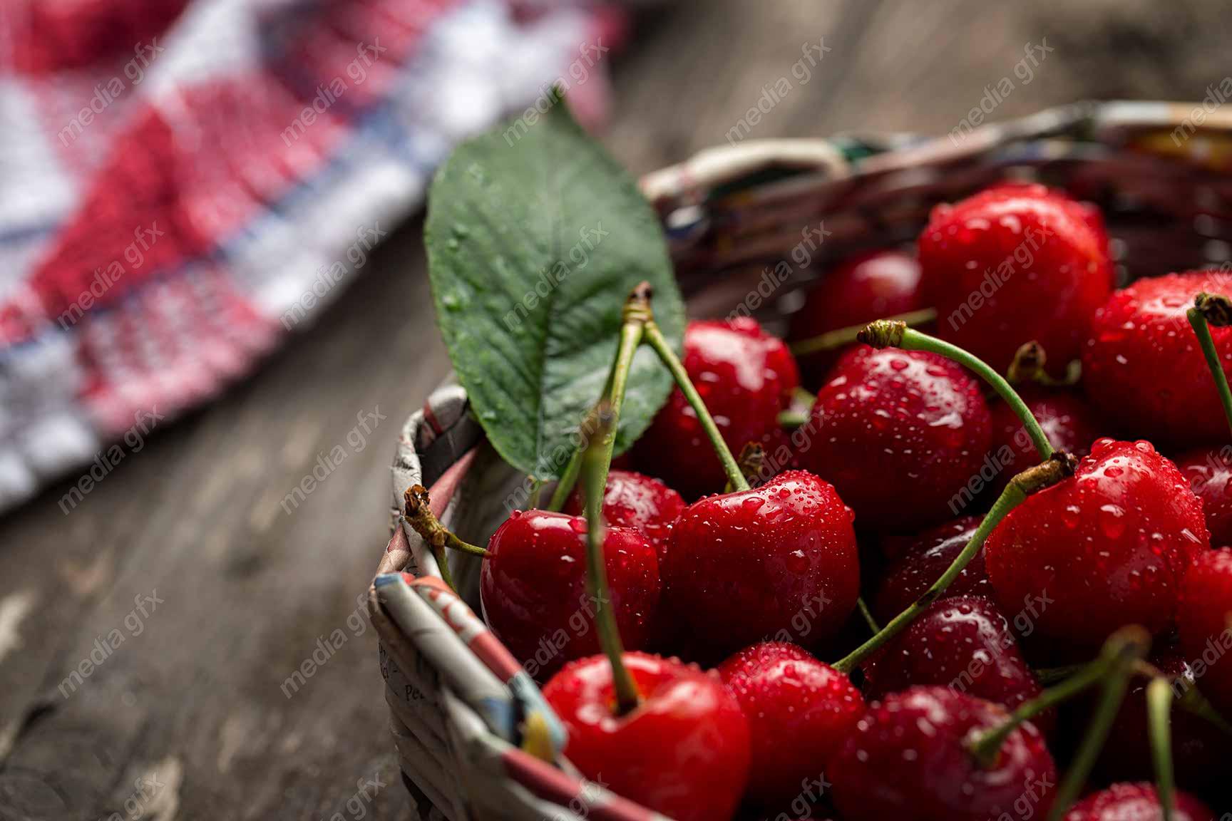 عکس با کیفیت گیلاس تازه روی میز چوبی MJ003704